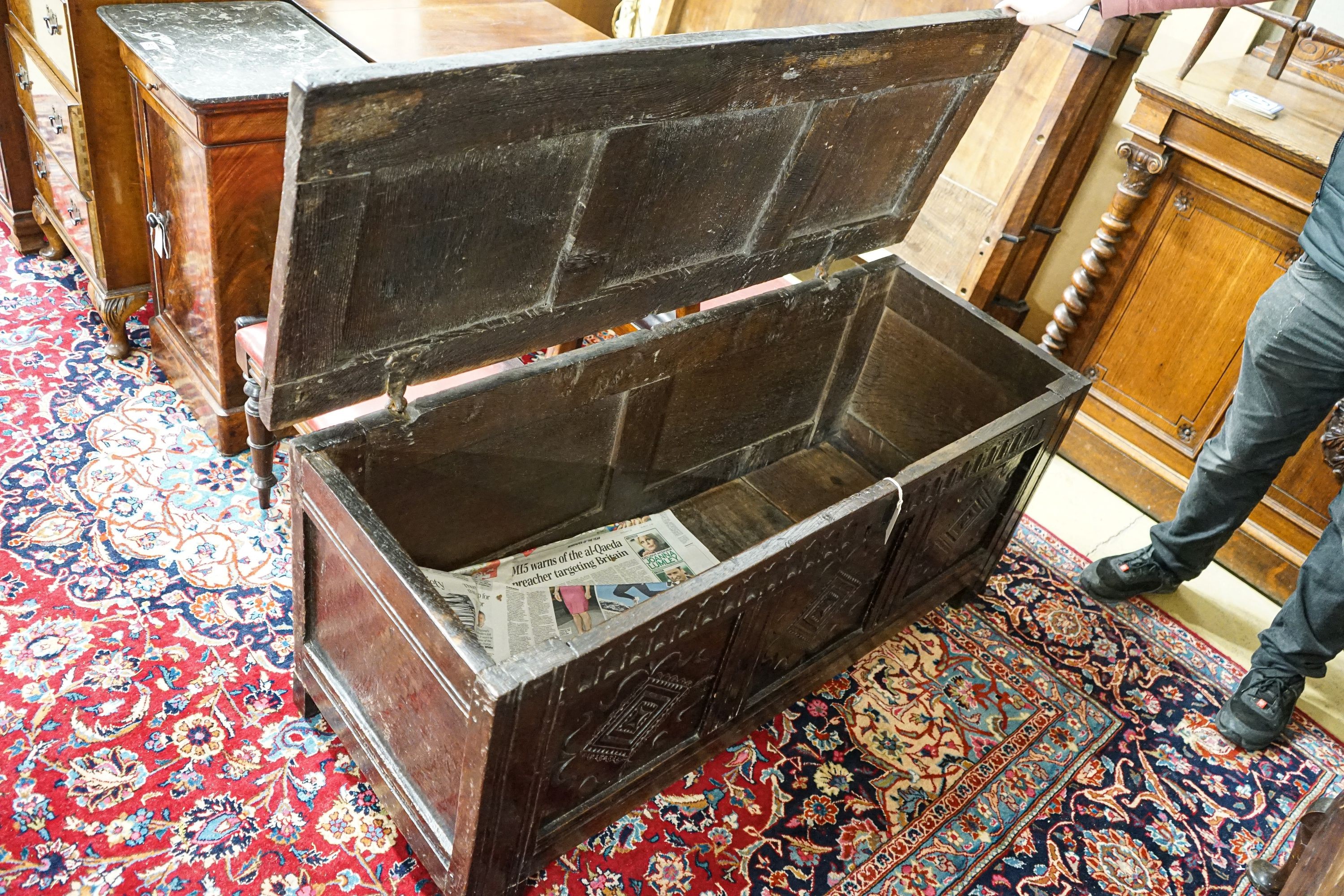 A late 17th/early 18th century carved and panelled oak coffer with hinged lid, width 136cm, depth 51cm, height 58cm